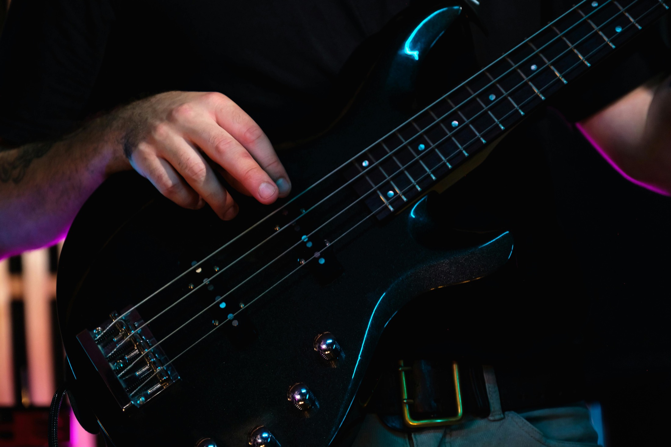 Close-up of hands playing bass guitar