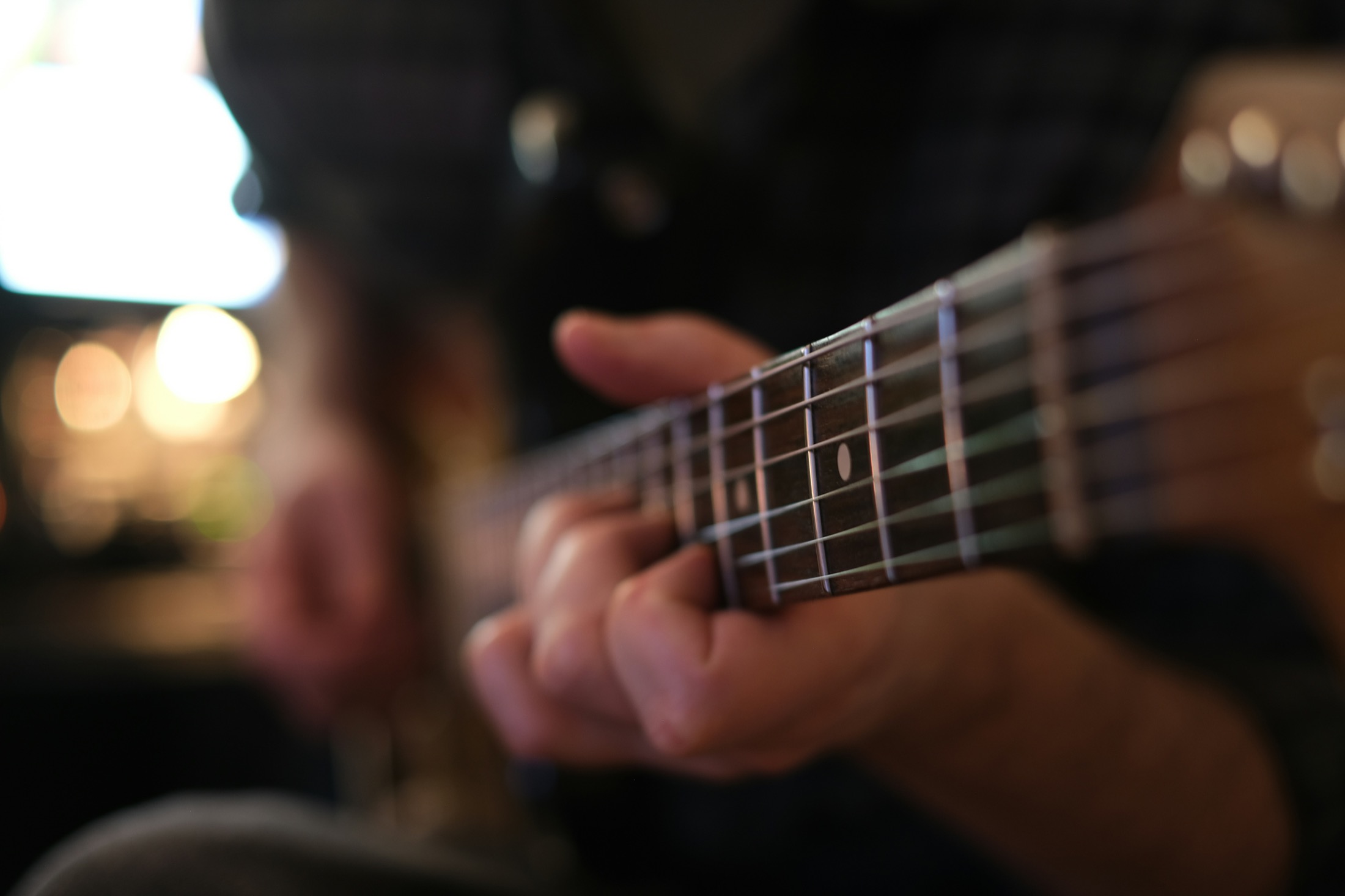 Close-up of a guitarist practicing on an electric guitar fretboard
